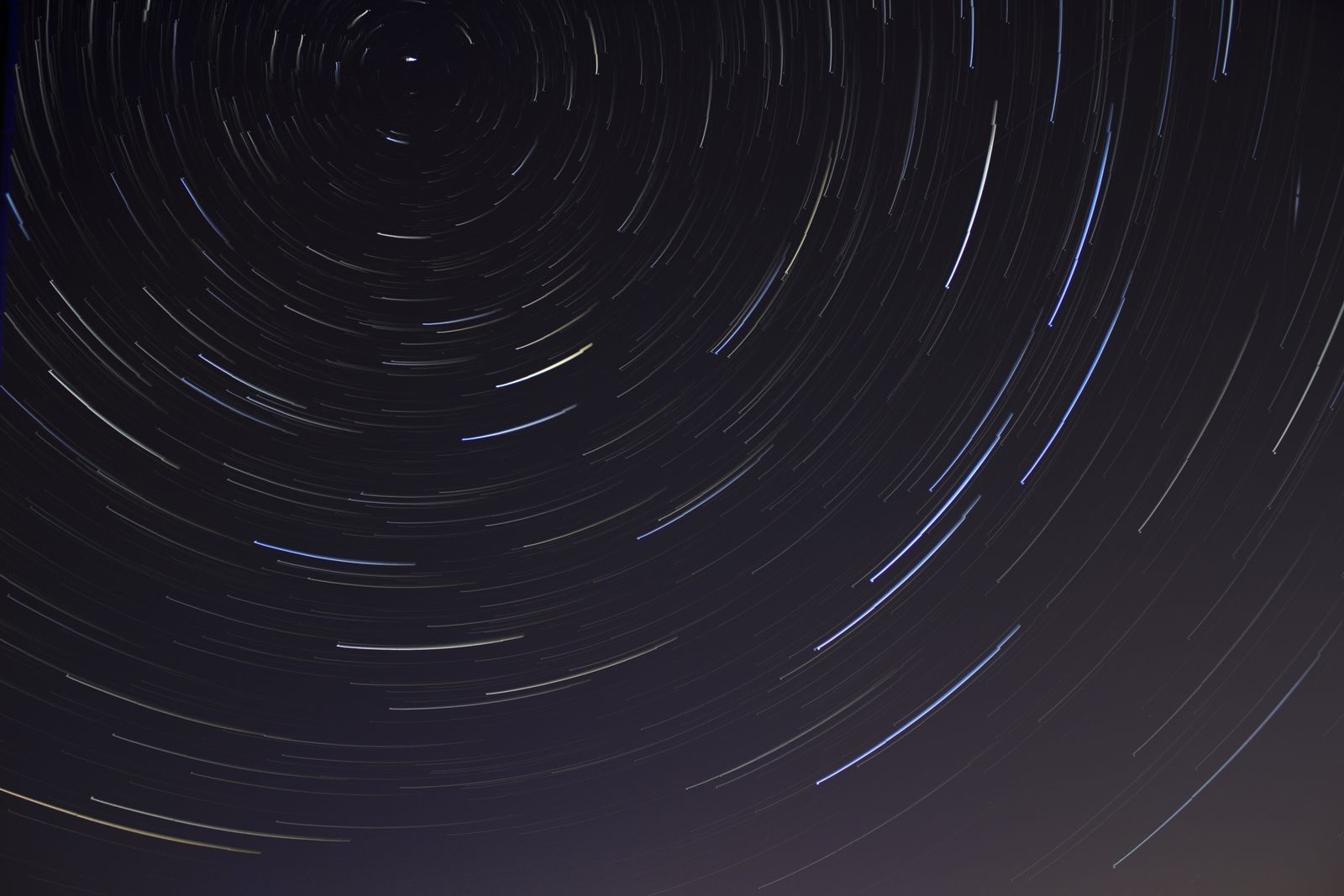Long-exposure star trails circling overhead, a continuously shifting backdrop